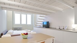 A modern, well-lit room with a bed, a dining table with chairs, a TV, and a window. - MILAN design Loft in great location (Milan)