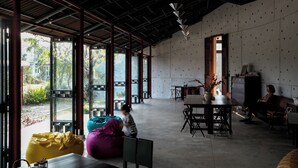 A spacious room with large windows, a dining area, and a seating area with a table and chairs. - De Hué Space (Hue)