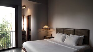 A bedroom with a large bed, a bedside lamp, and a view of greenery outside. - De Hué Space (Hue)