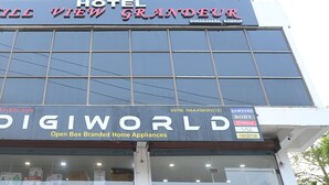 Um hotel chamado Hill View Grandeur em Dorakahara, Kamrup, com uma loja DIGI WORLD logo abaixo.