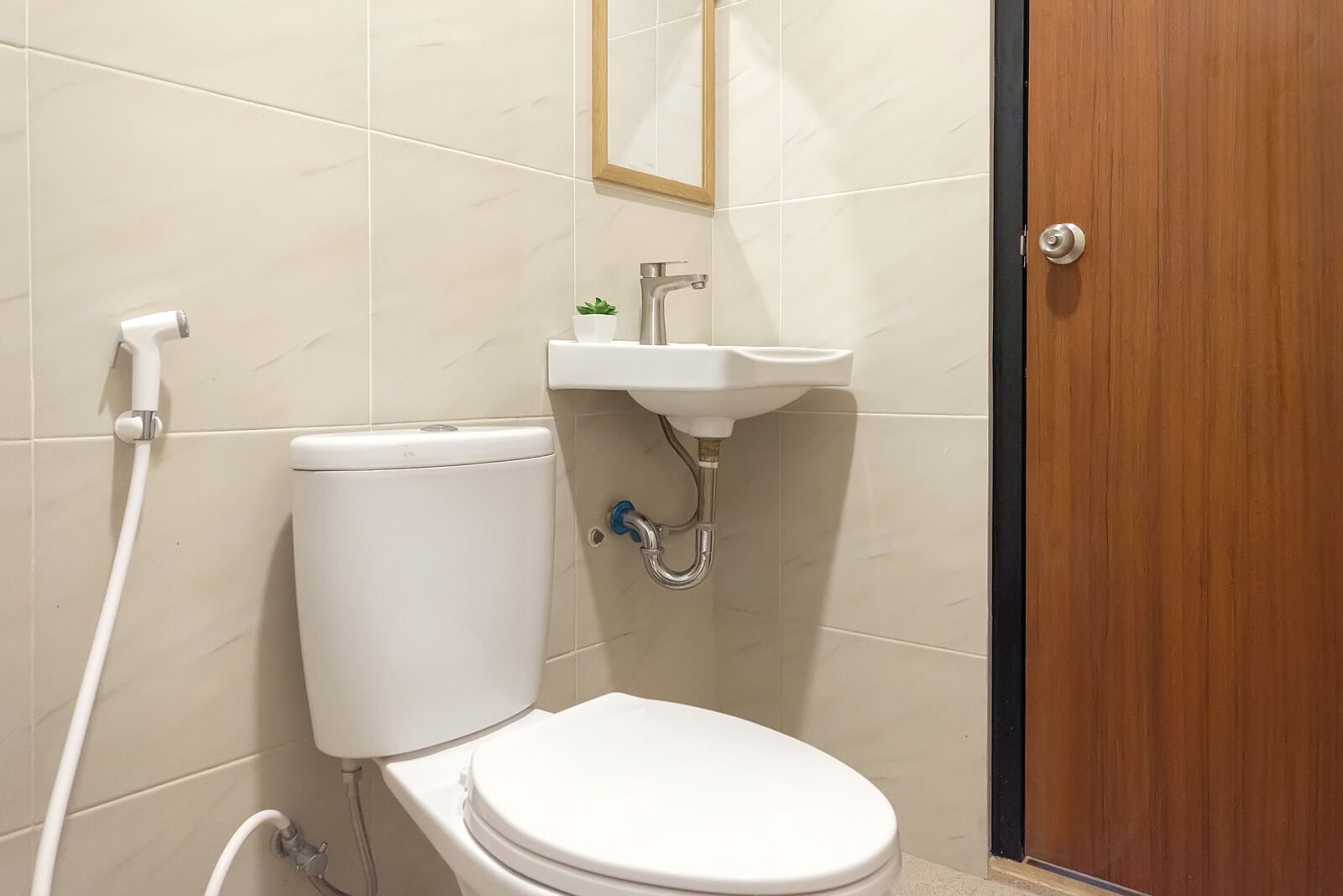 Uma casa de banho pequena com sanita, lavatório e chuveiro.