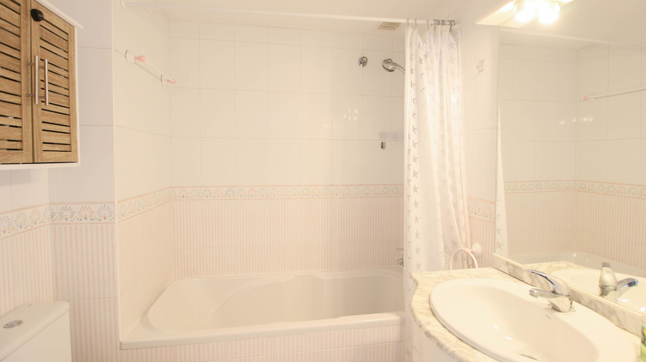 Une salle de bain avec une baignoire, un lavabo et un rideau de douche.