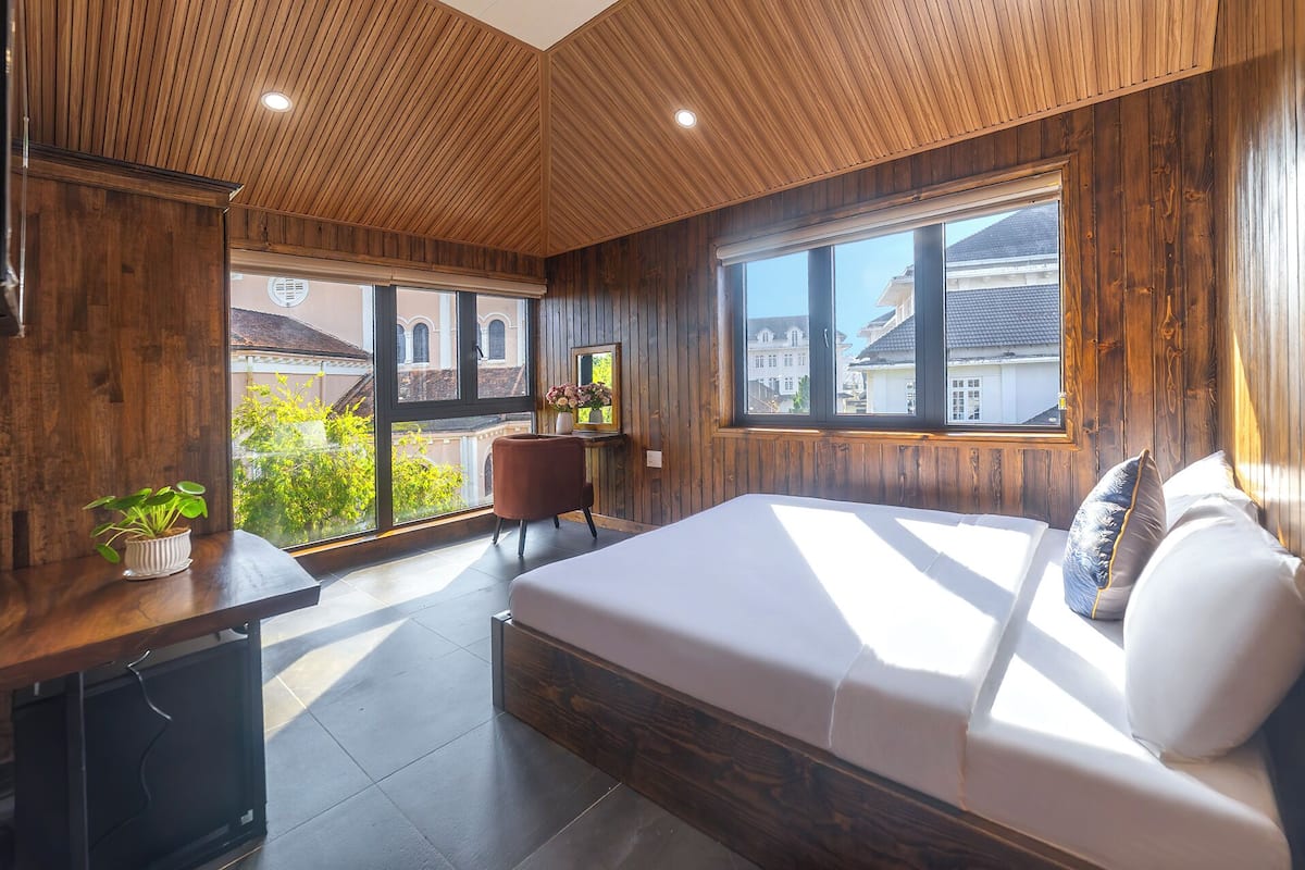 Ein Schlafzimmer mit einem Bett, einem Schreibtisch, einem Stuhl und einem Fenster.