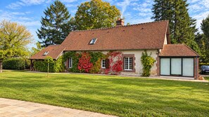 A two-story house with a sloped roof, a covered porch, and a garage.
