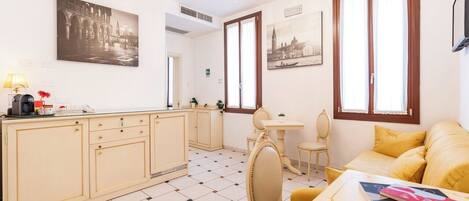 A compact living space with a kitchenette, dining area, and a sofa.