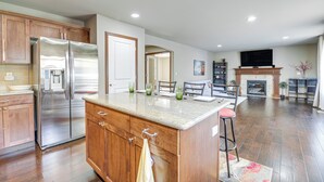A spacious kitchen with wooden cabinets, a stainless steel refrigerator, and a granite countertop. - Family-Friendly Home w/ Patio & Garden in Everett! (Everett)