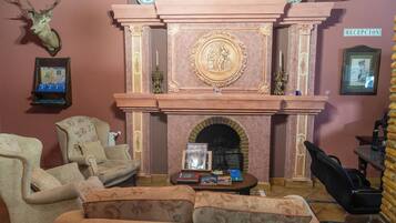Een gezellige woonkamer met een open haard, twee fauteuils, een bank en een salontafel.
