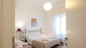 Ein Schlafzimmer mit zwei Betten, einem Nachttisch, einer Lampe und einem Bild an der Wand.