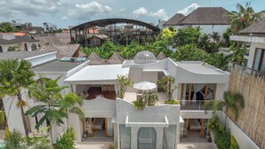 A modern villa with a swimming pool, multiple balconies, and lush greenery. - Villa Milana (Canggu)