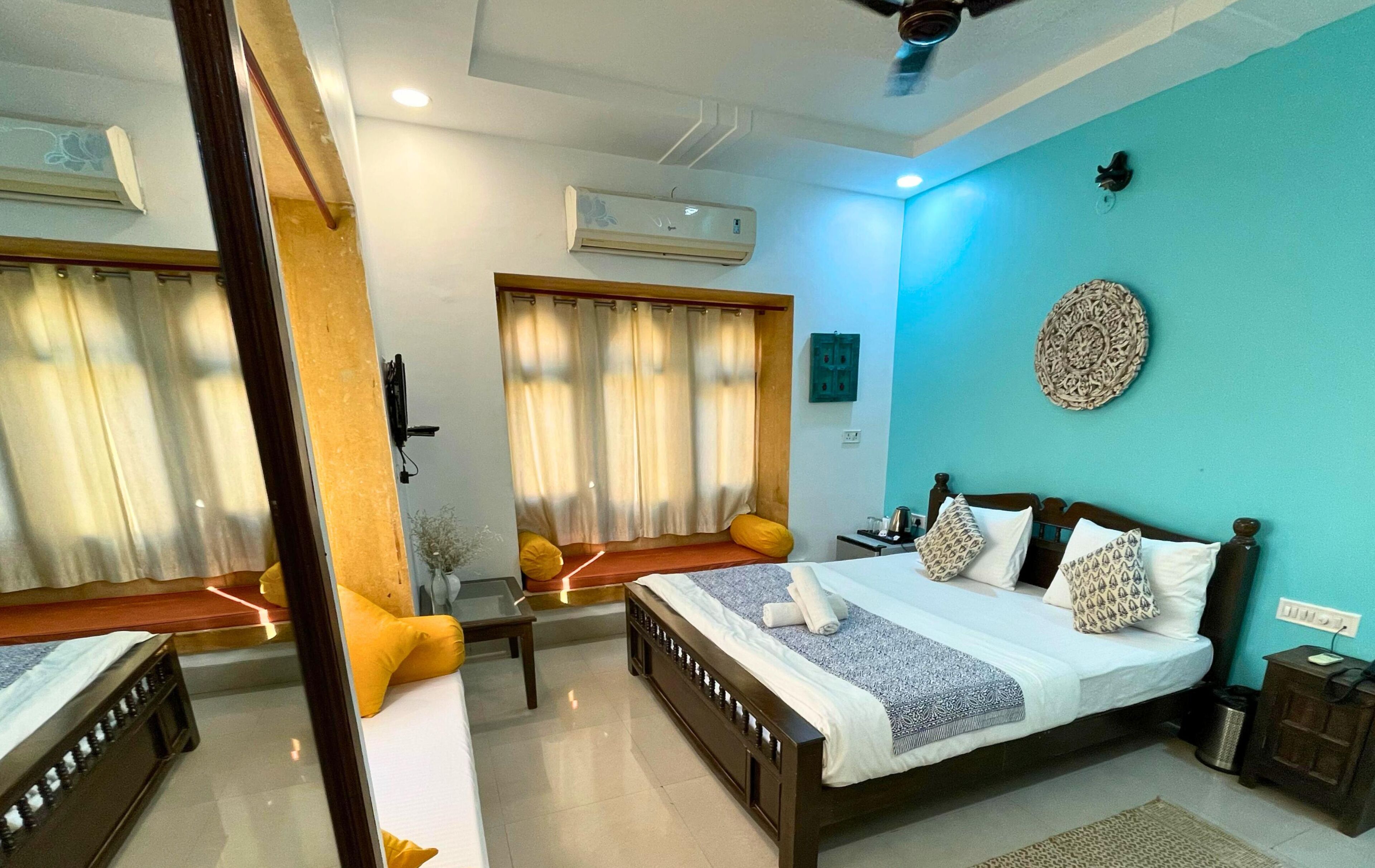 Una habitación de hotel con cama, mesita de noche y espejo.