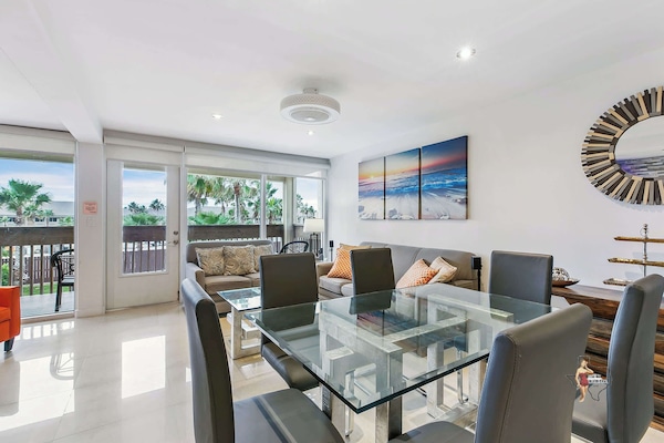 The dining area features a glass table that comfortably seats