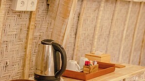 A wooden table with a kettle, a cup, and a tray with items. - Wijaya Cottage Nusa Penida (Penida Island)