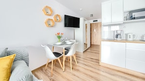 A modern kitchen with white cabinets, a built-in microwave, and a coffee maker.