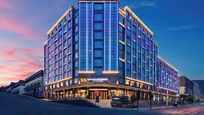 A multi-story hotel with a prominent Days Hotel sign, large windows, and a well-lit entrance. - Days Hotel by Wyndham Renhuai Canglong (Zunyi)