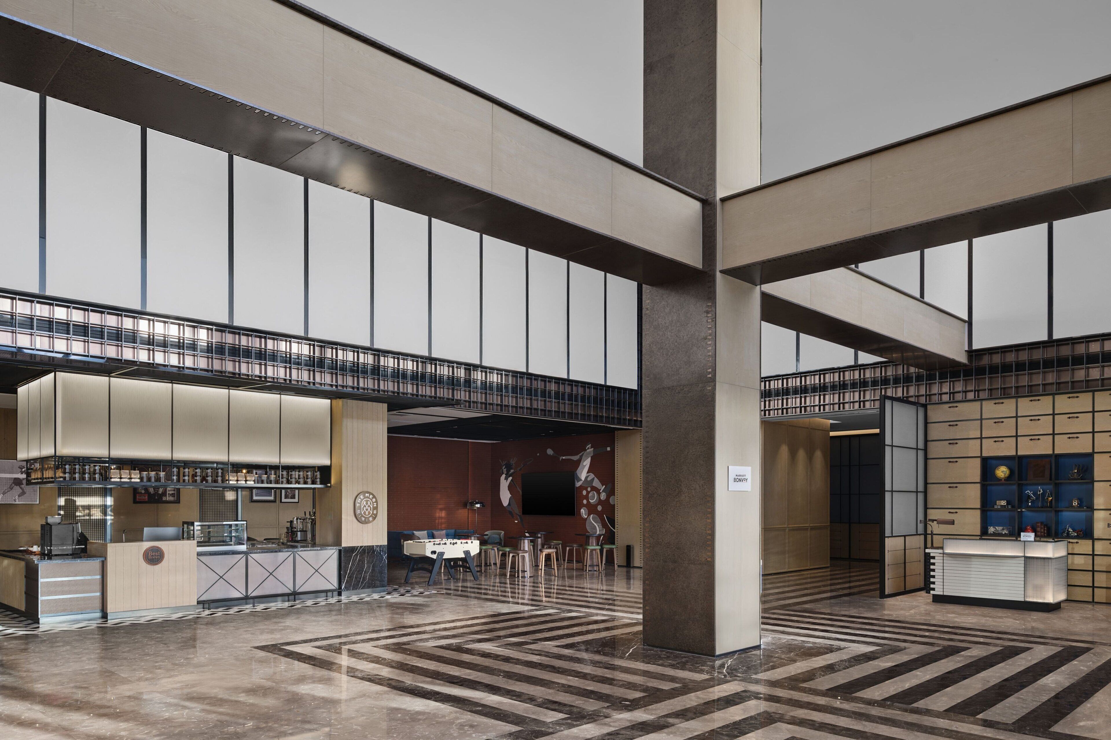 A spacious lobby with a foosball table, a reception desk, and a bar area.