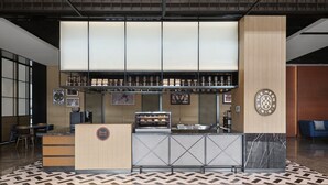 A modern bar area with a counter, shelves with bottles, and a wall-mounted sign. - Four Points Datong Pingcheng (Datong)