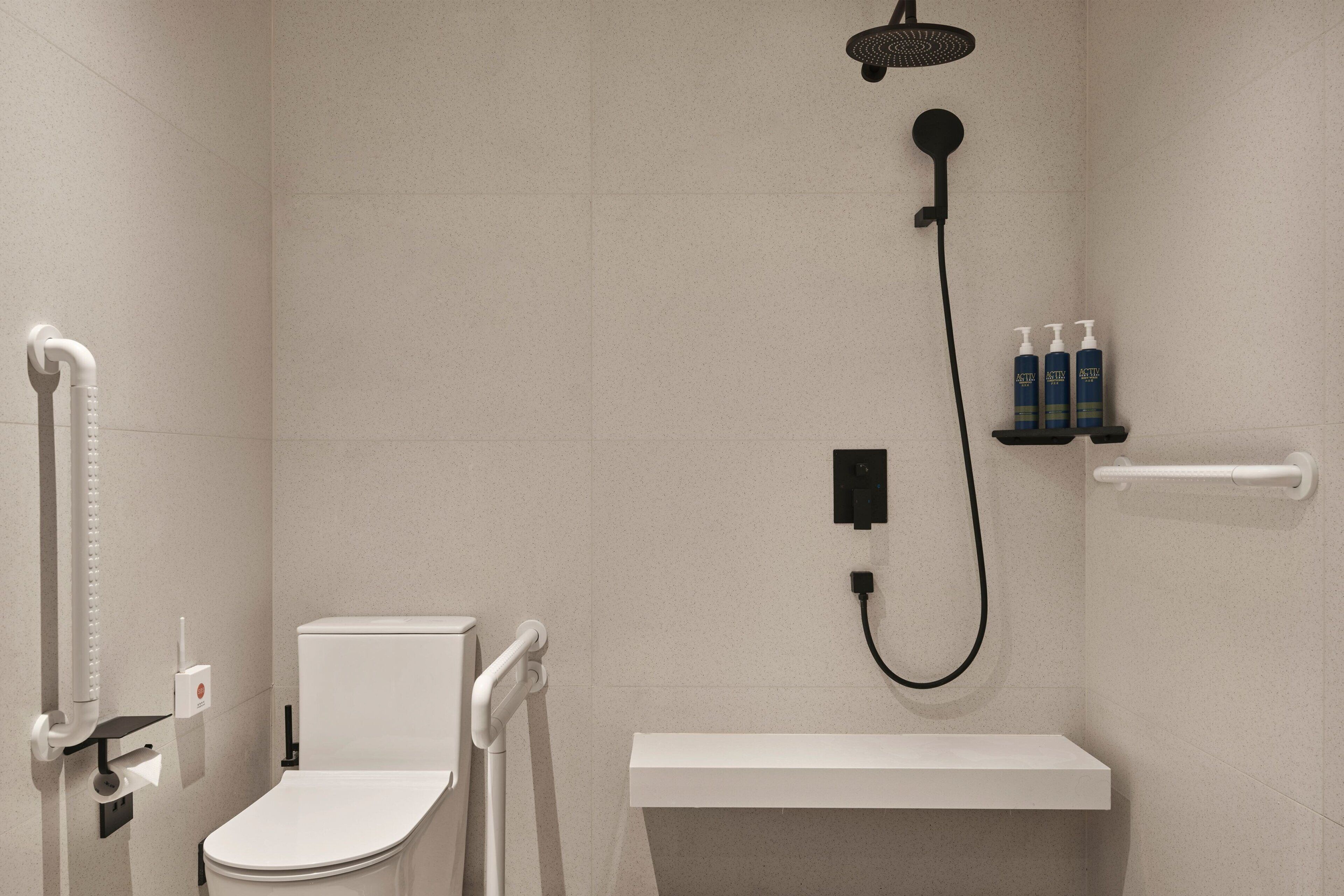 A modern bathroom with a toilet, a shower, and a shelf with toiletries.