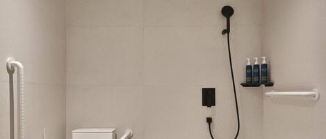 A modern bathroom with a toilet, a shower, and a shelf with toiletries.