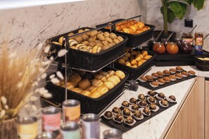 A buffet with various baked goods and pastries.