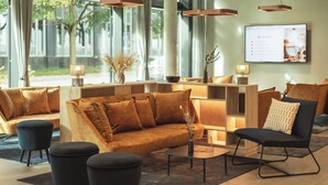 Eine moderne Lobby mit einer Couch, Sesseln und einem Couchtisch.