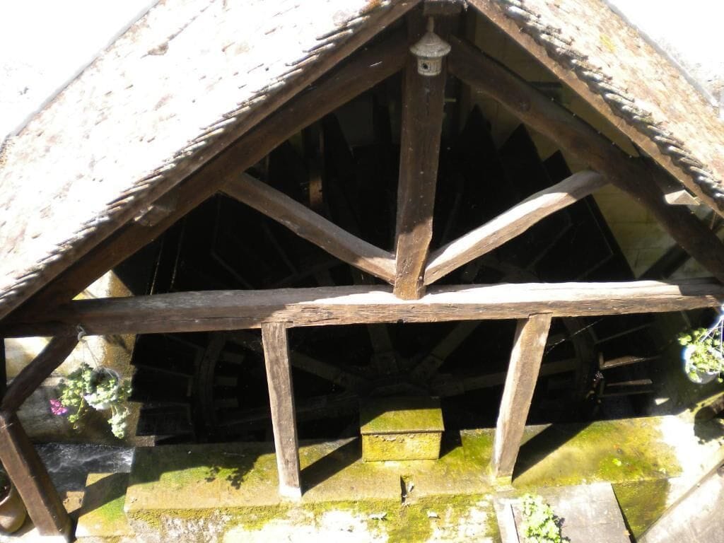Una estructura de madera con techo triangular y un poste central de soporte.