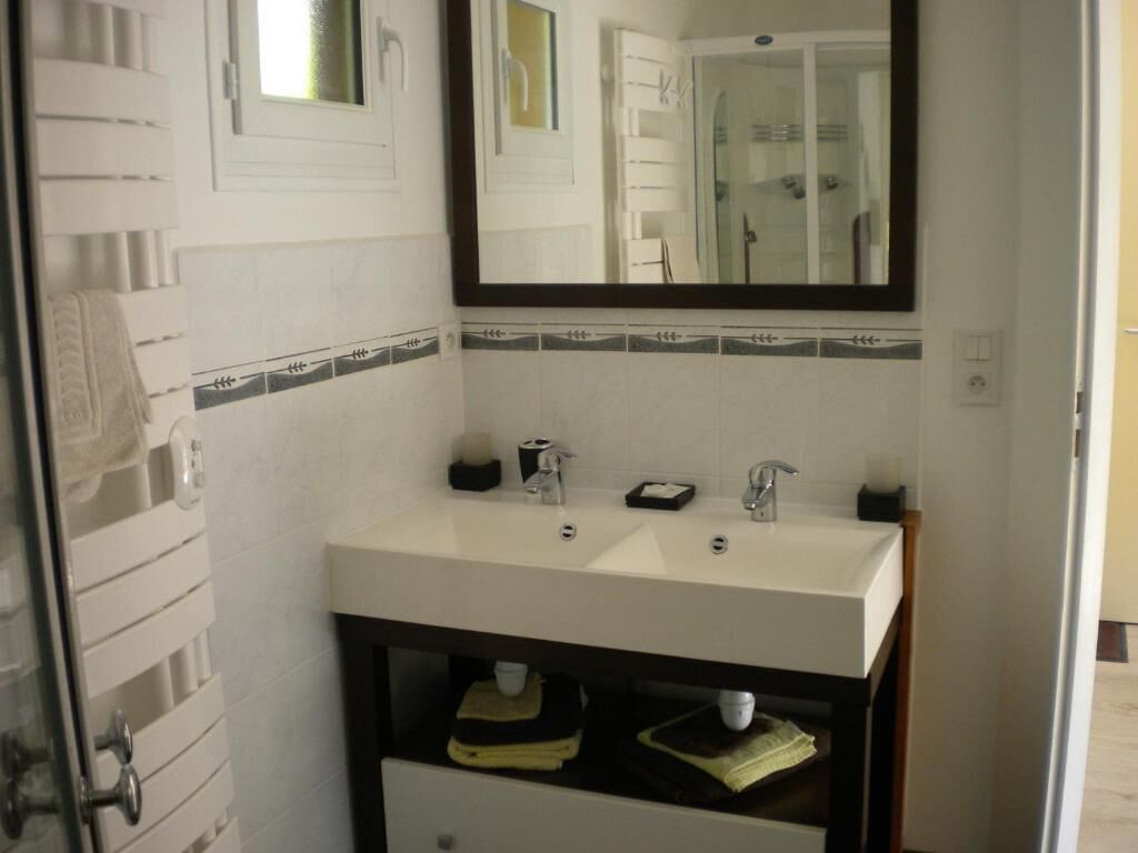A bathroom with a white sink, a mirror, and a towel rack.
