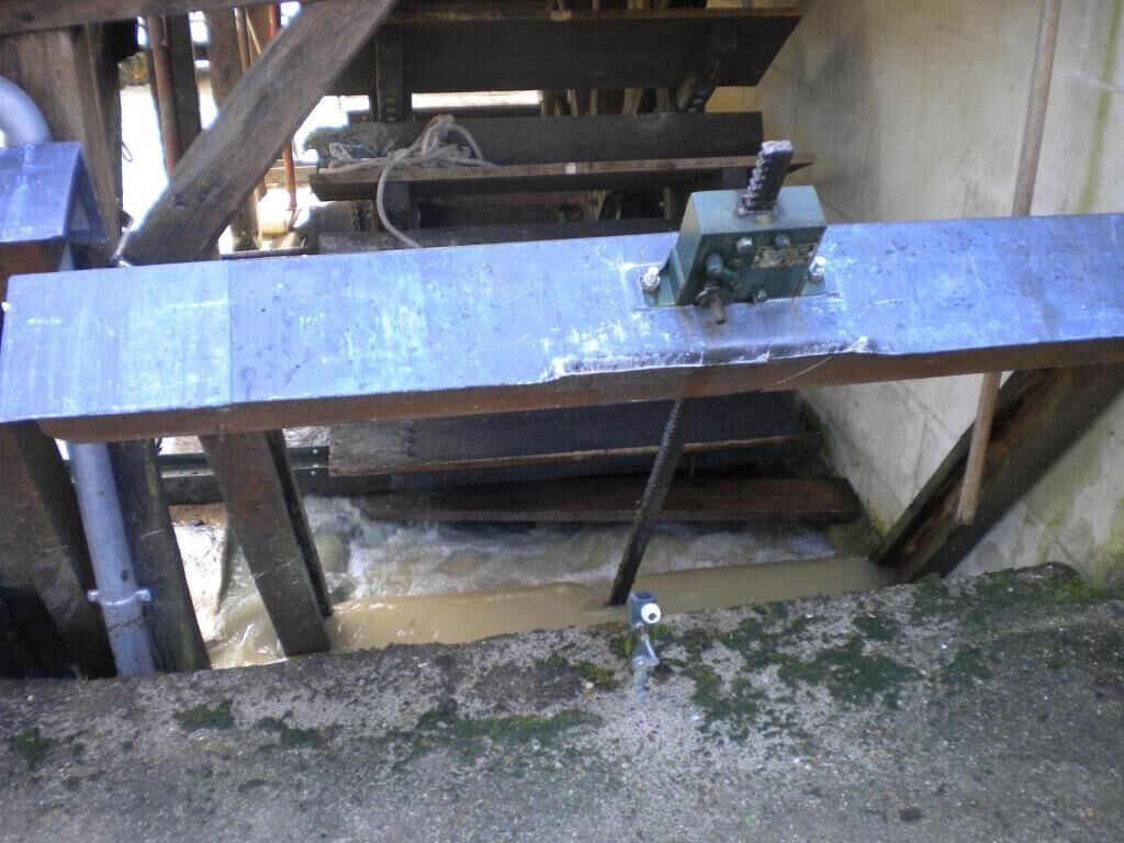 A metal beam supported by wooden beams, with a pulley system attached.