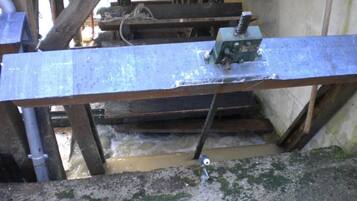 A metal beam supported by wooden beams, with a pulley system attached.