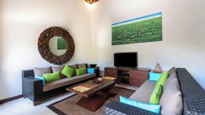 A modern living room with a sofa, coffee table, and TV. - Senang Villa by Betterplace (Canggu)
