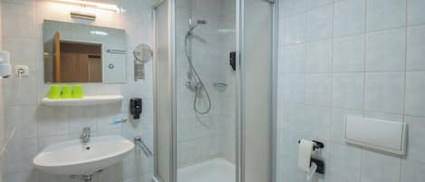 A modern bathroom with a glass-enclosed shower, a sink, and a toilet.