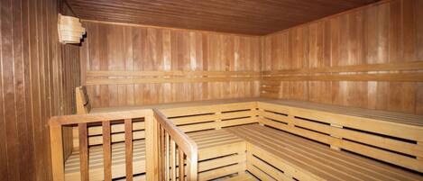 Una sauna con bancos de madera y un banco con respaldo.
