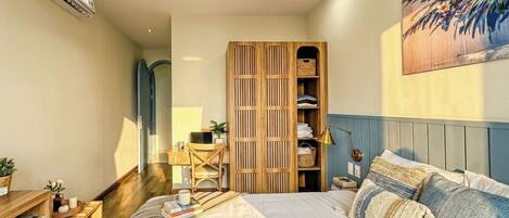 A bedroom with a bed, bedside tables, a wardrobe, and a desk with a chair.