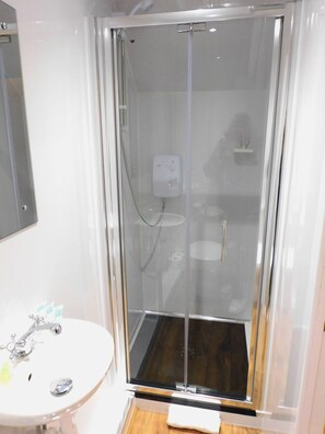 A bathroom with a glass-enclosed shower, a white sink, and a mirror. - Newly refurbished 3 bedroom home in East Kilbride - 52 (East Kilbride)