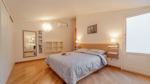 Un dormitorio con cama, mesitas de noche, un espejo y un cuadro en la pared.