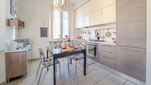 Una cocina moderna con una mesa de comedor, sillas y una lámpara colgante.