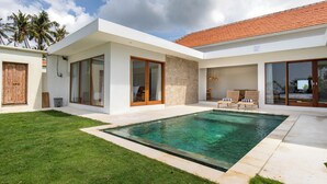 Una casa moderna con piscina, ventanas amplias y césped cuidado.