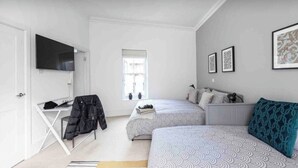 A bedroom with two beds, a desk, a TV, and a window. -  Spacious -First Floor- 4 beds -2 bath (London)