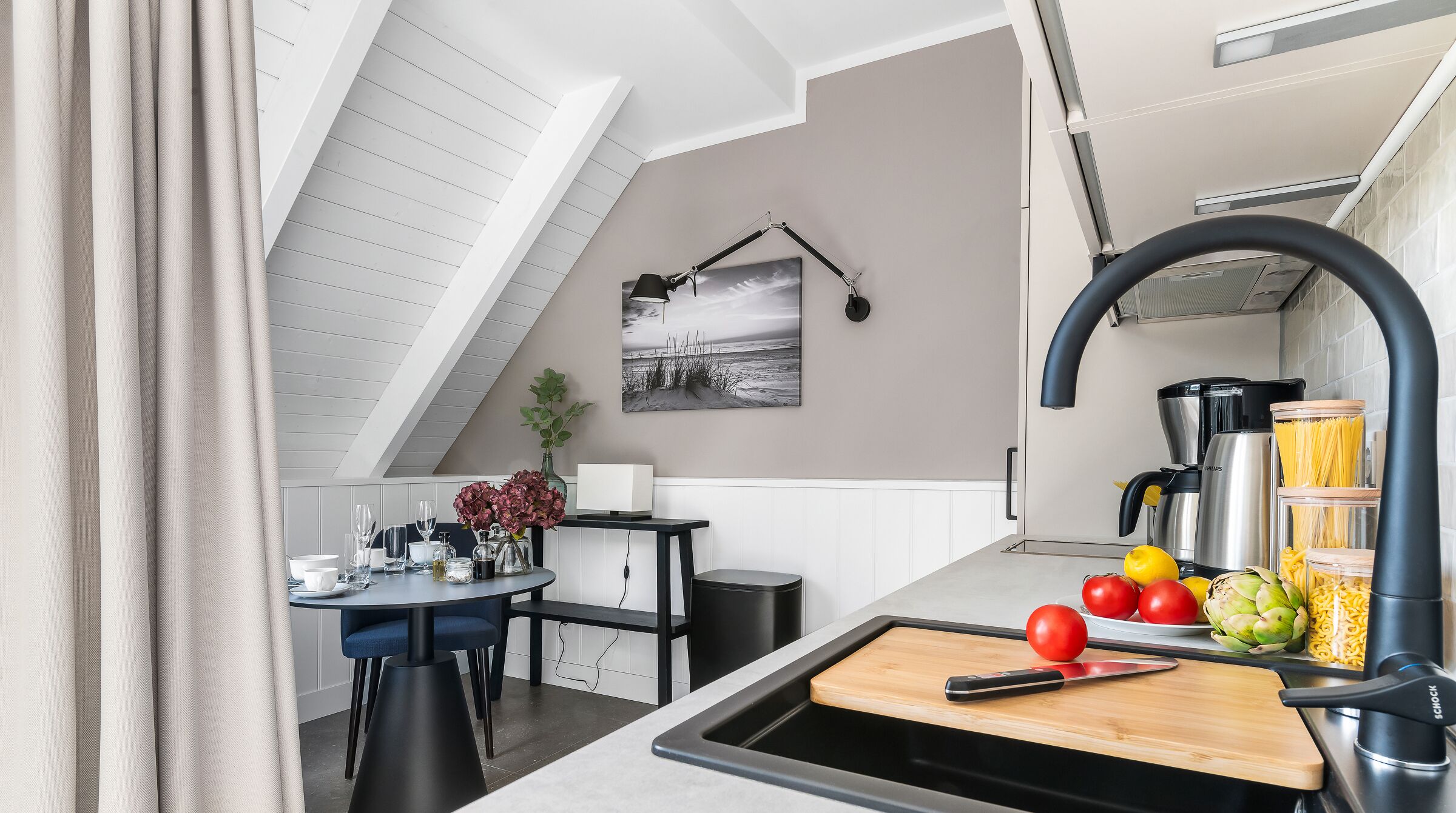A modern kitchen with a black faucet, a wooden cutting board, and various food items.