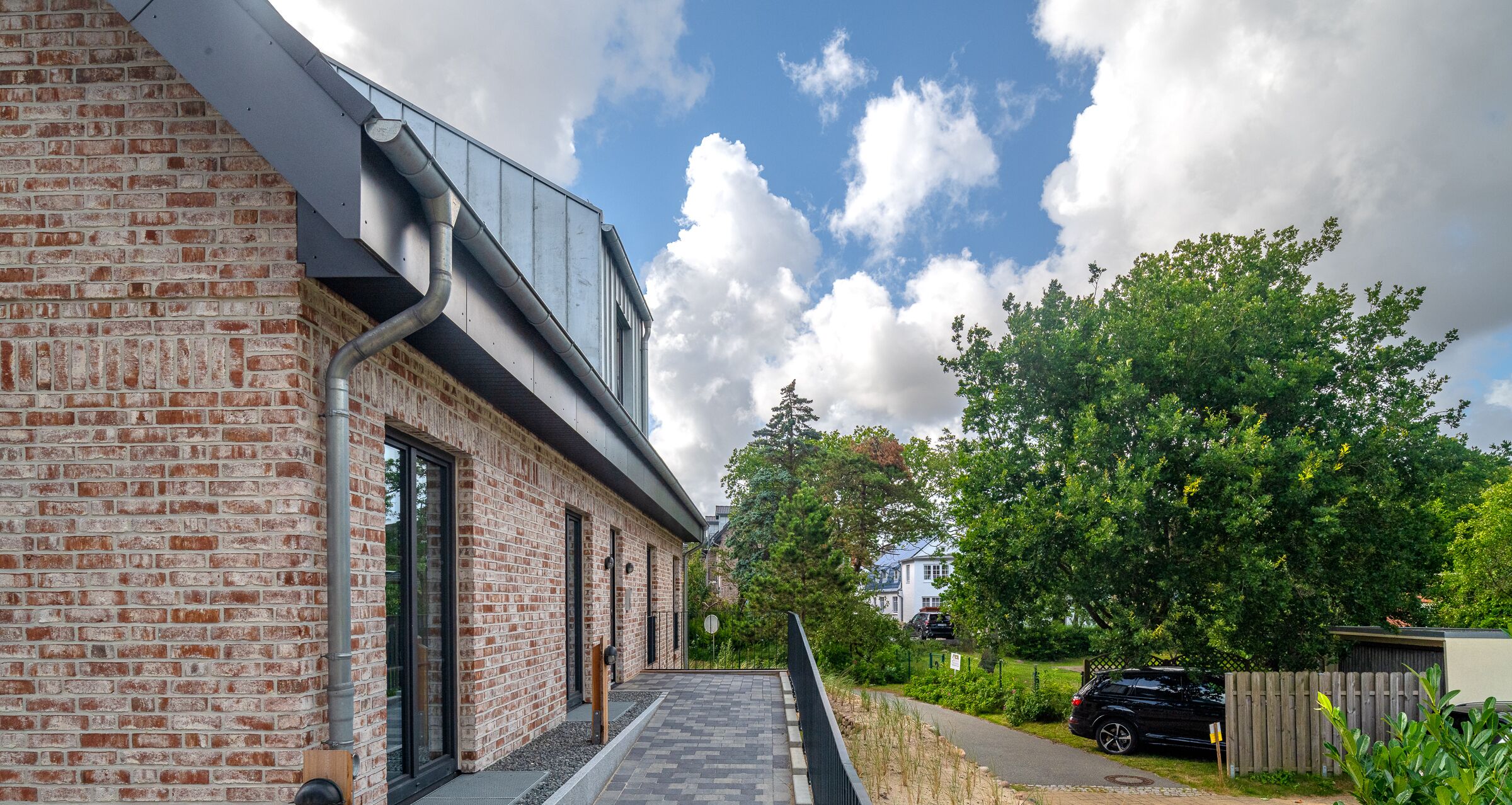 Un bâtiment moderne en briques, doté d’un toit plat et de grandes fenêtres.