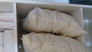 A storage compartment with neatly folded blankets and two large beige pillows. - Lovely apartment 170m from thermal baths - 5 guests (La Roche-Posay)