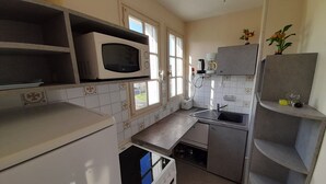 Eine kleine Küche mit Mikrowelle, Toaster und Spüle.