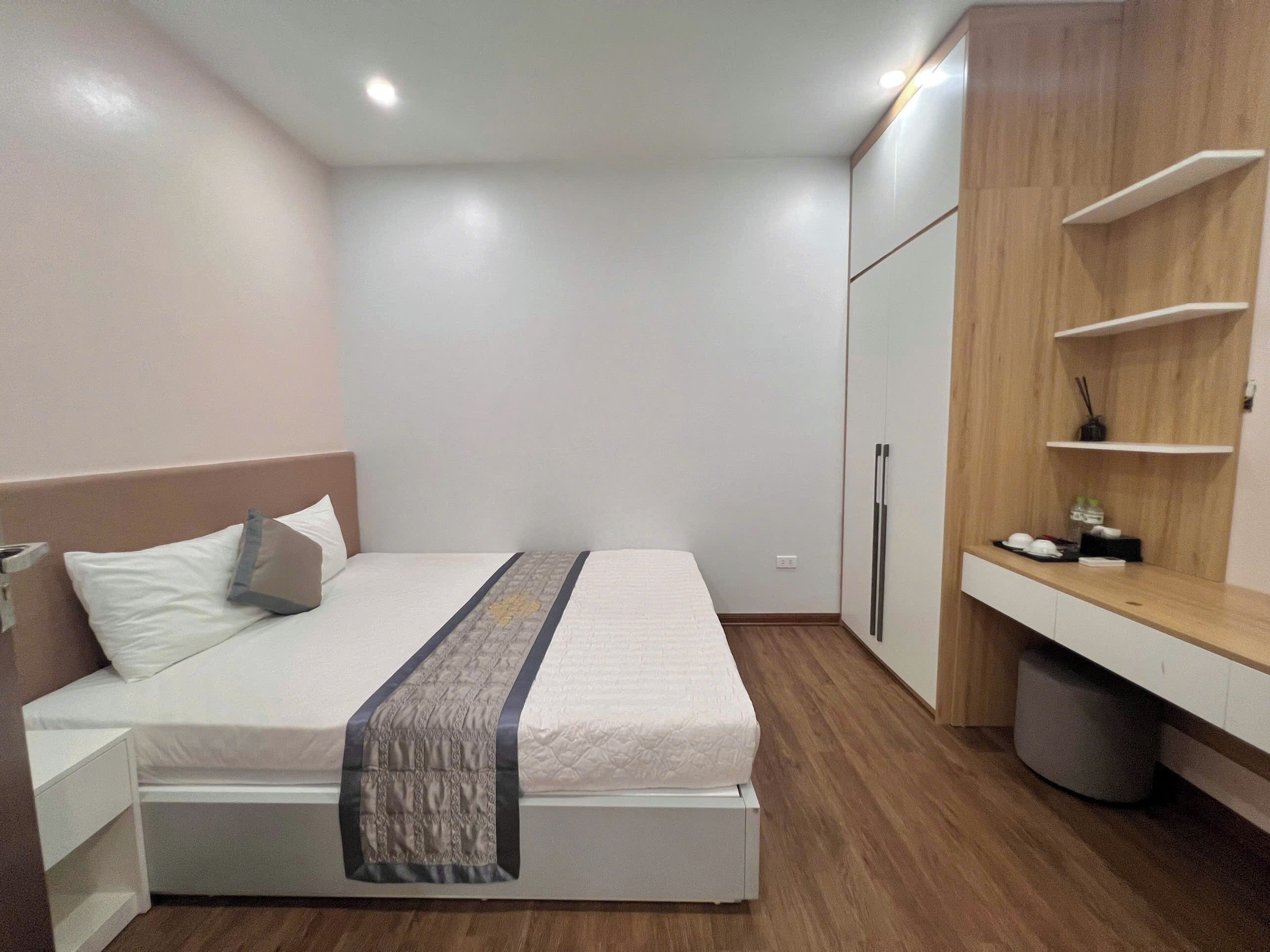 Una camera da letto con un letto, comodini, un armadio e una piccola scrivania con una sedia.