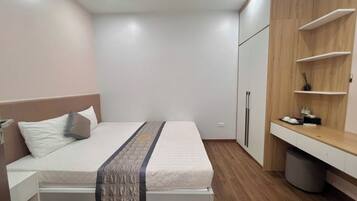 Una camera da letto con un letto, comodini, un armadio e una piccola scrivania con una sedia.