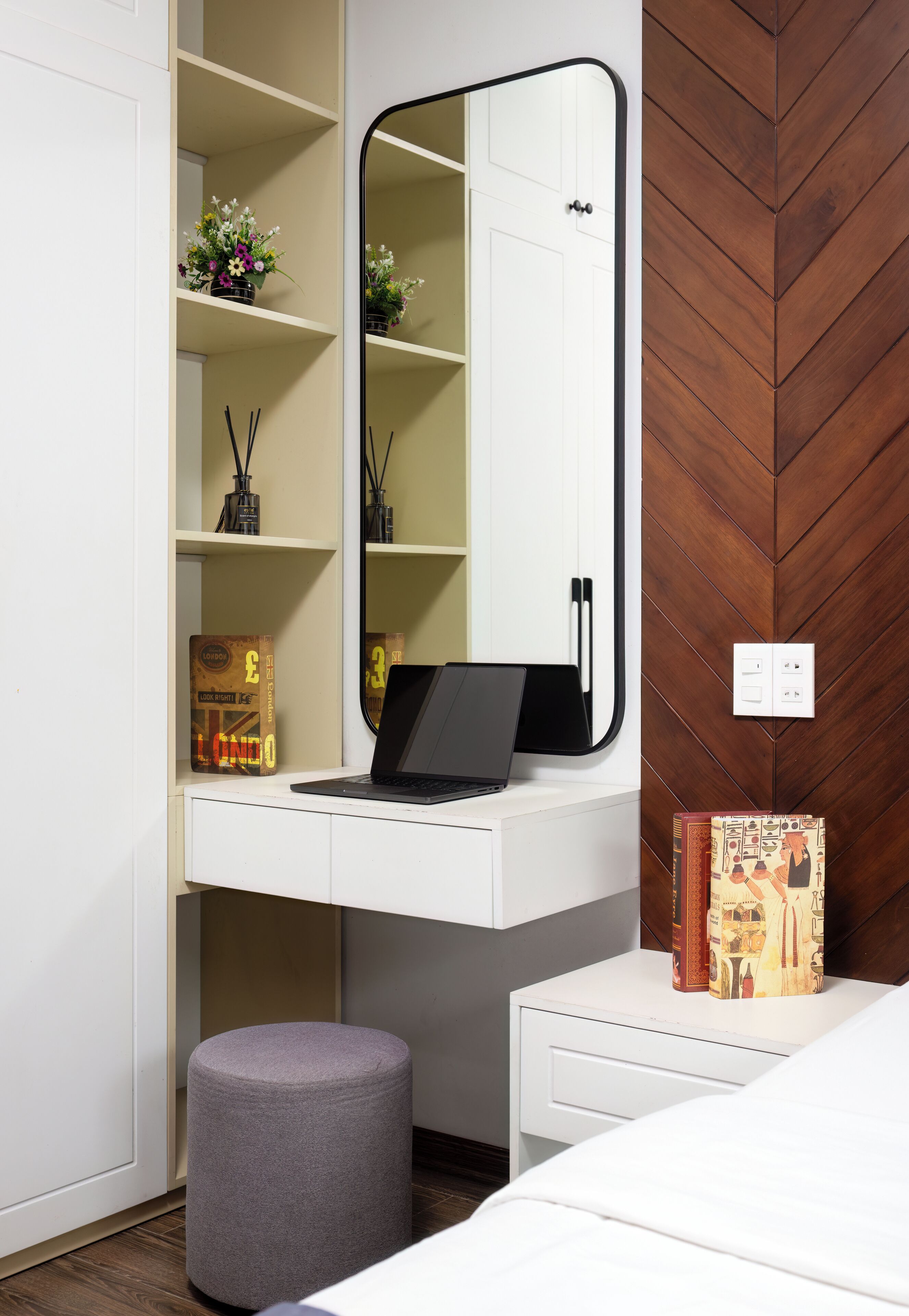 Un dormitorio con escritorio blanco, computadora portátil, espejo y cama.