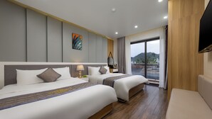 A hotel room with two beds, a sofa, a TV, and a balcony with a view. - Cat Ba Seoul 2 Hotel & Apartment (Hai Phong)