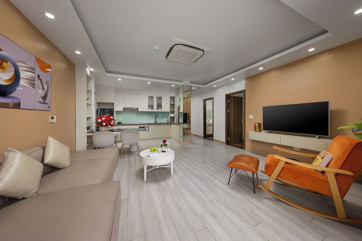 A modern living room with a sofa, a coffee table, a TV, and a rocking chair.