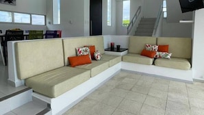 A modern living room with a large L-shaped sectional sofa, a staircase, and a flat-screen TV mounted on the wall. - In Espinal Casaquinta (Espinal)