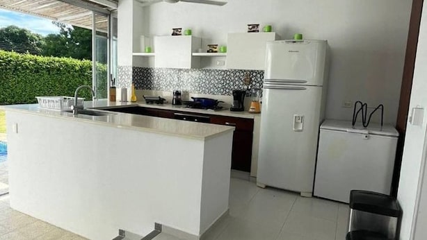A modern kitchen with a central island, white cabinetry, and a built-in oven. - In Espinal Casaquinta (Espinal)