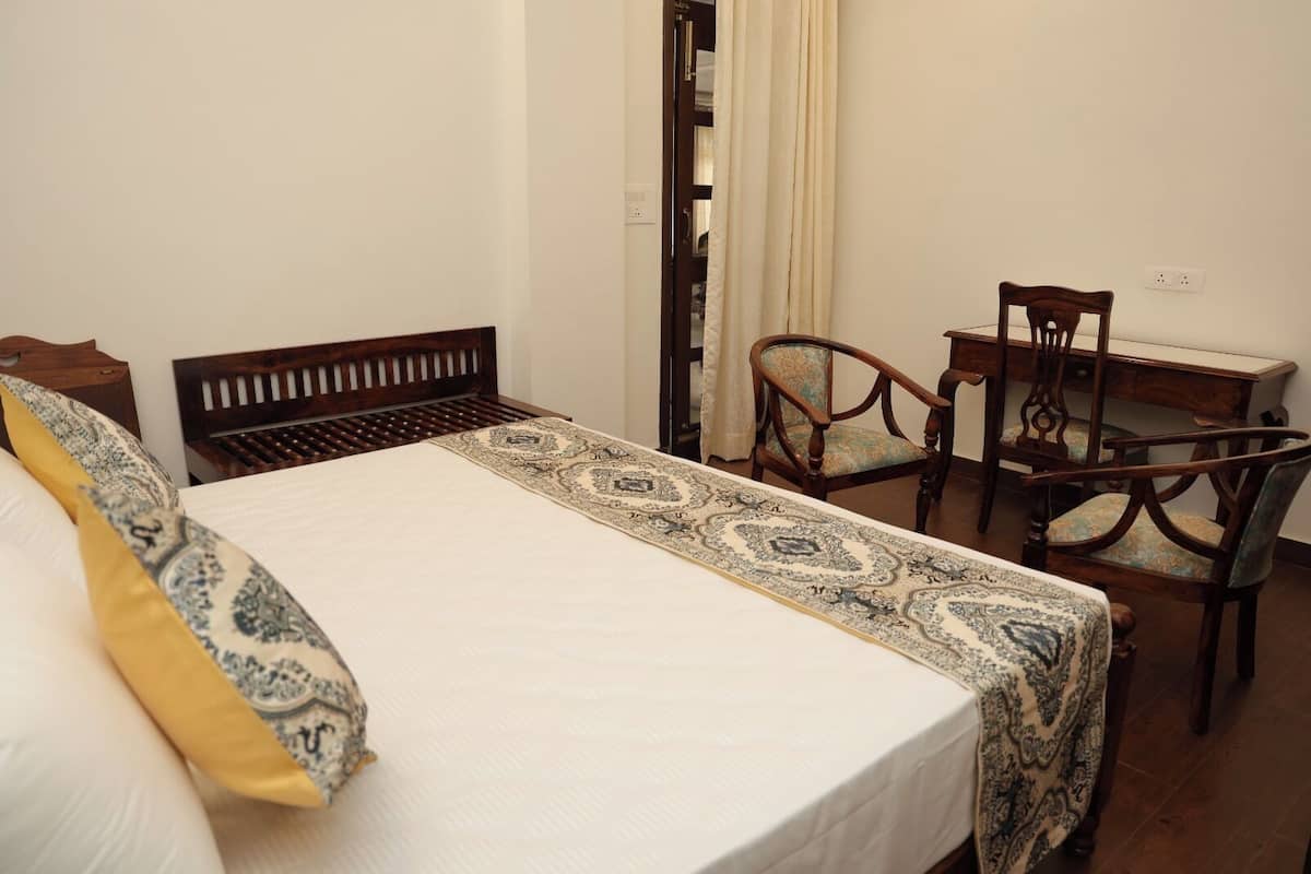 A bedroom with a bed, a chair, and a desk.