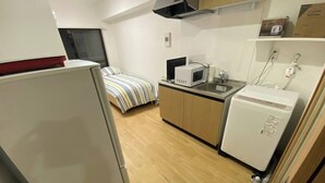A compact kitchen with a refrigerator, microwave, sink, and a small fridge. - W110 - Quaint Sakurashinmachi - Newly Renovated Unit with Two Beds  (Setagaya City)